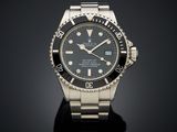 a close up of a watch on a black surface with a black background