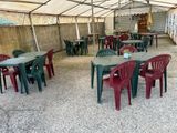 des tables et des chaises disposées sous un chapiteau dans une cour
