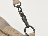 beige and black handbag with zippers on a white background