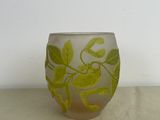 a glass vase with green leaves on it on a table