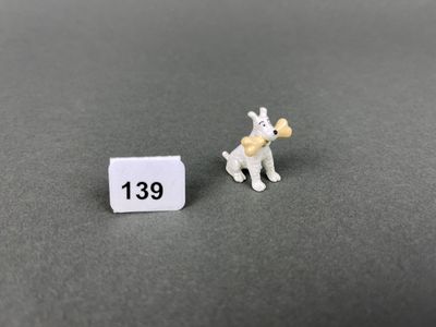 a close up of a small toy dog next to a small sign