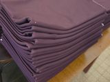 une pile de serviettes violettes pliées posée sur une table en bois