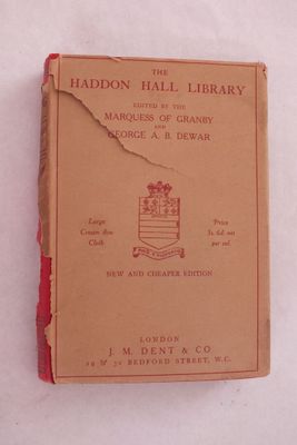 un livre marron à la couverture rouge posé sur une surface blanche