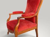 a red chair with a wooden frame and red upholstered seat