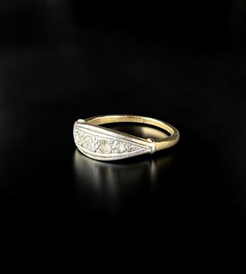 a close up of a gold and diamond ring on a black surface
