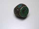Gros plan sur une bague ornée d'une pierre verte