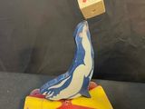 a small wooden bird sitting on top of a toy car with a block on top of it