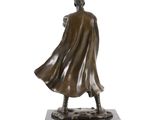 bronze statue of a man in a cloak and boots on a marble base