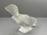 a glass bird that is sitting on top of a table