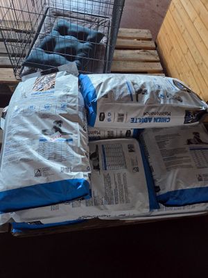 a pile of bags of food on a pallet next to a shopping cart