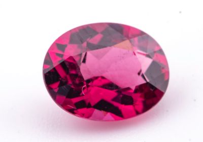 un gros plan d'un diamant rose sur une surface blanche