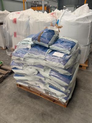 une palette remplie de sacs de ciment dans un entrepôt