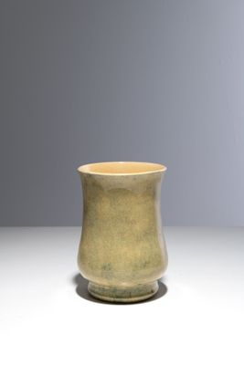 une image représentant une tasse verte posée sur une table blanche