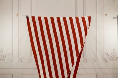 a large red and white striped flag hanging from a rope