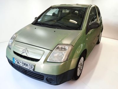 a picture of a small green car parked in a white room