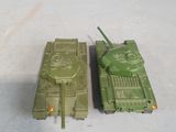 two toy tanks sitting next to each other on a white surface