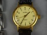a close up of a wrist watch with a gold case
