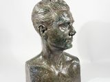 bronze bust of a man with short hair on a white background