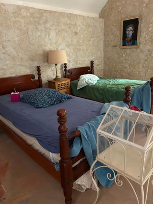two beds in a room with a birdcage on the bed