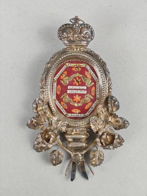 un insigne rouge et or orné d'une couronne