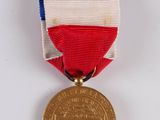 an image of a medal with a red, white, and blue ribbon
