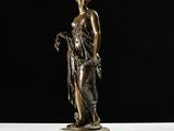 a bronze statue of a woman holding flowers on a marble base