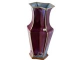 un vase violet posé sur une surface blanche