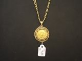 une pièce d'or à laquelle est attachée une étiquette au bout d'une chaîne