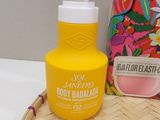 an image of a bottle of body balm sitting on top of a basket