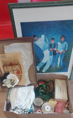 une boîte de matériel de couture posée sur une table à côté d'une photo encadrée