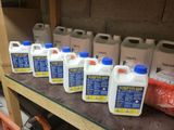 Plusieurs gallons de liquide sont alignés sur une étagère dans un garage