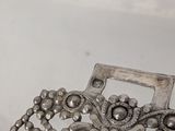 an image of a silver necklace with a flower design on it