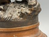 une statue en bronze représentant un homme à cheval, posée sur un socle