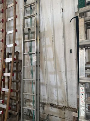 several ladders are lined up against a wall in a warehouse