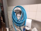 un tuyau bleu accroché au mur à côté d'un évier