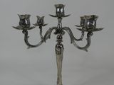 une image représentant un chandelier en argent sur lequel sont posées trois bougies