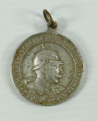 une vieille médaille en argent sur laquelle figure l'image d'un homme coiffé d'un chapeau