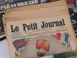 a pile of newspapers with a picture of a man in a turban