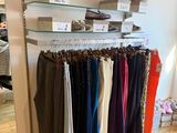 a lot of clothes hanging on a rack in a store