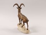 statue of a goat standing on a rock on a white background