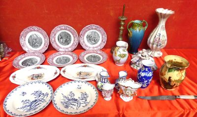 de nombreuses assiettes et vases posés sur une table recouverte d'une nappe rouge
