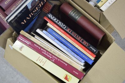 une boîte pleine de livres posée sur le sol