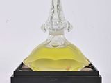 un flacon de parfum en verre transparent avec un socle noir sur fond blanc