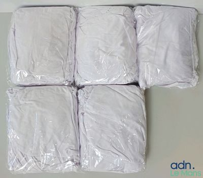 six oreillers blancs sont emballés dans du plastique sur une table