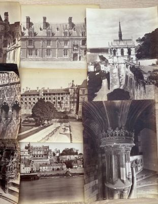 Plusieurs vieilles photos de bâtiments et d'architecture sont exposées sur une table