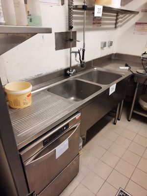 une cuisine équipée d'un évier et d'un lave-vaisselle