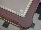 a wooden table with a glass top on a tiled floor