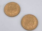 two gold coins sitting next to each other on a white surface