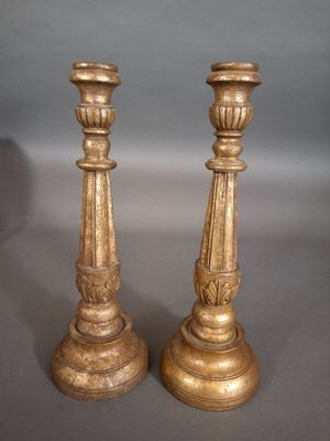 pair of antique brass candlesticks on a grey background