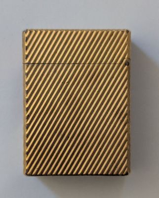 un étui à cigarettes plaqué or orné d'un motif en diagonale